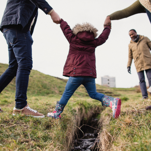 Child being helped to cross a river